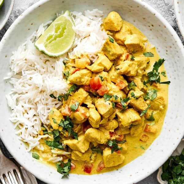 A plate of rice and coconut curry chicken.