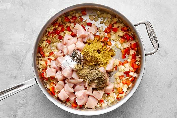 Cooked chicken and veggies in a pan.