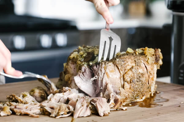 Shredding the cooked pork shoulder.