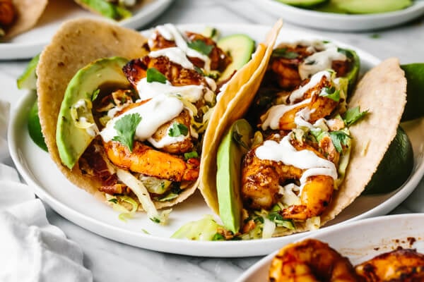 Shrimp tacos on a plate with lime crema.