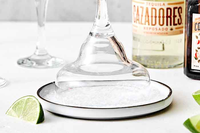 Adding margarita salt to a glass.