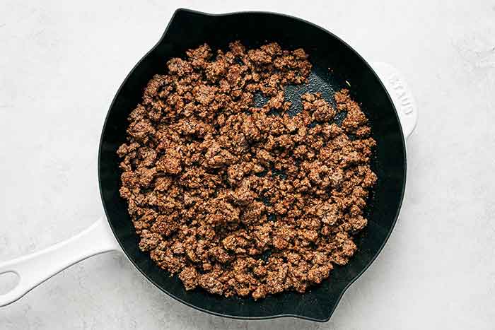 Cooked ground beef in a skillet.
