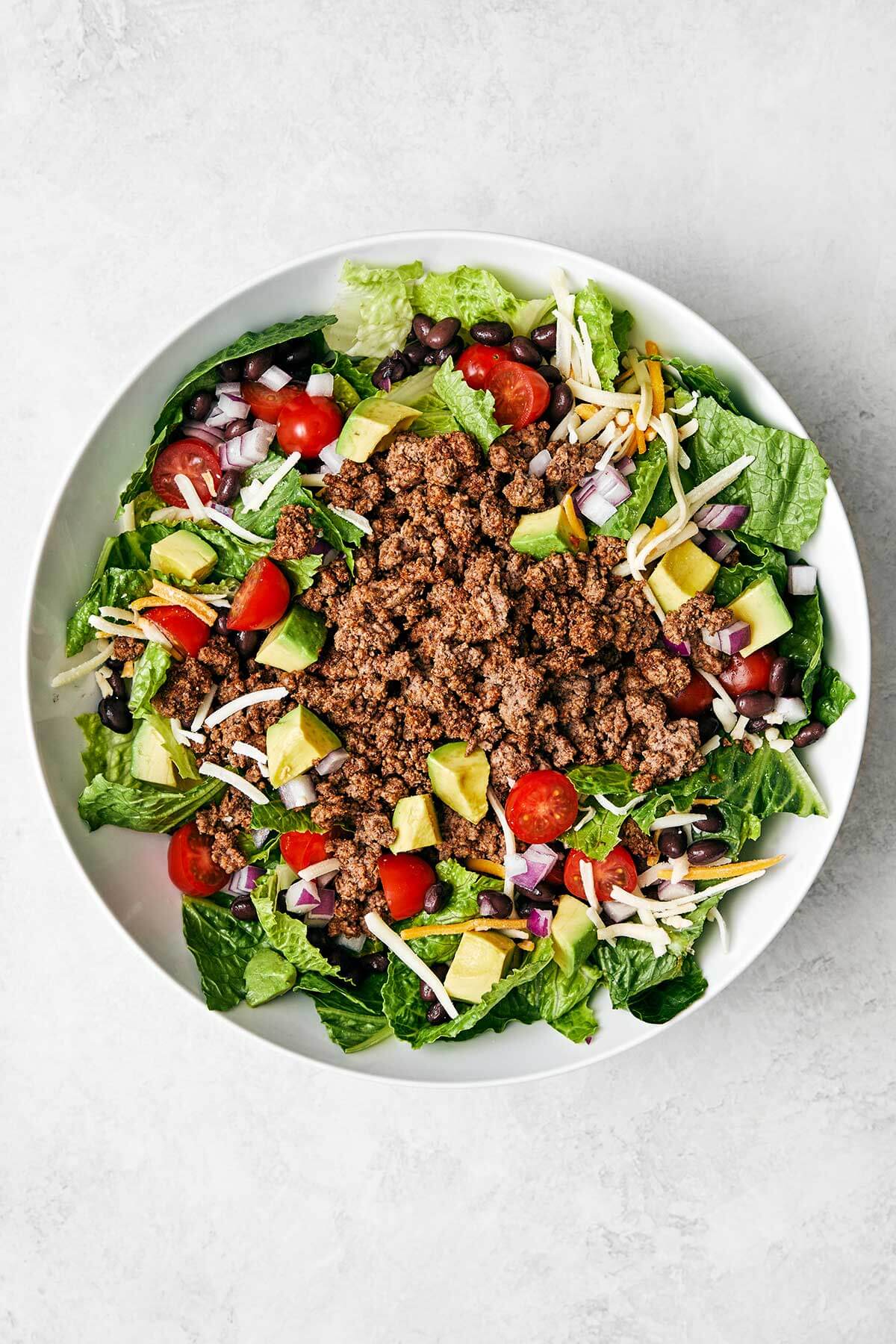 Making a taco salad in a bowl.