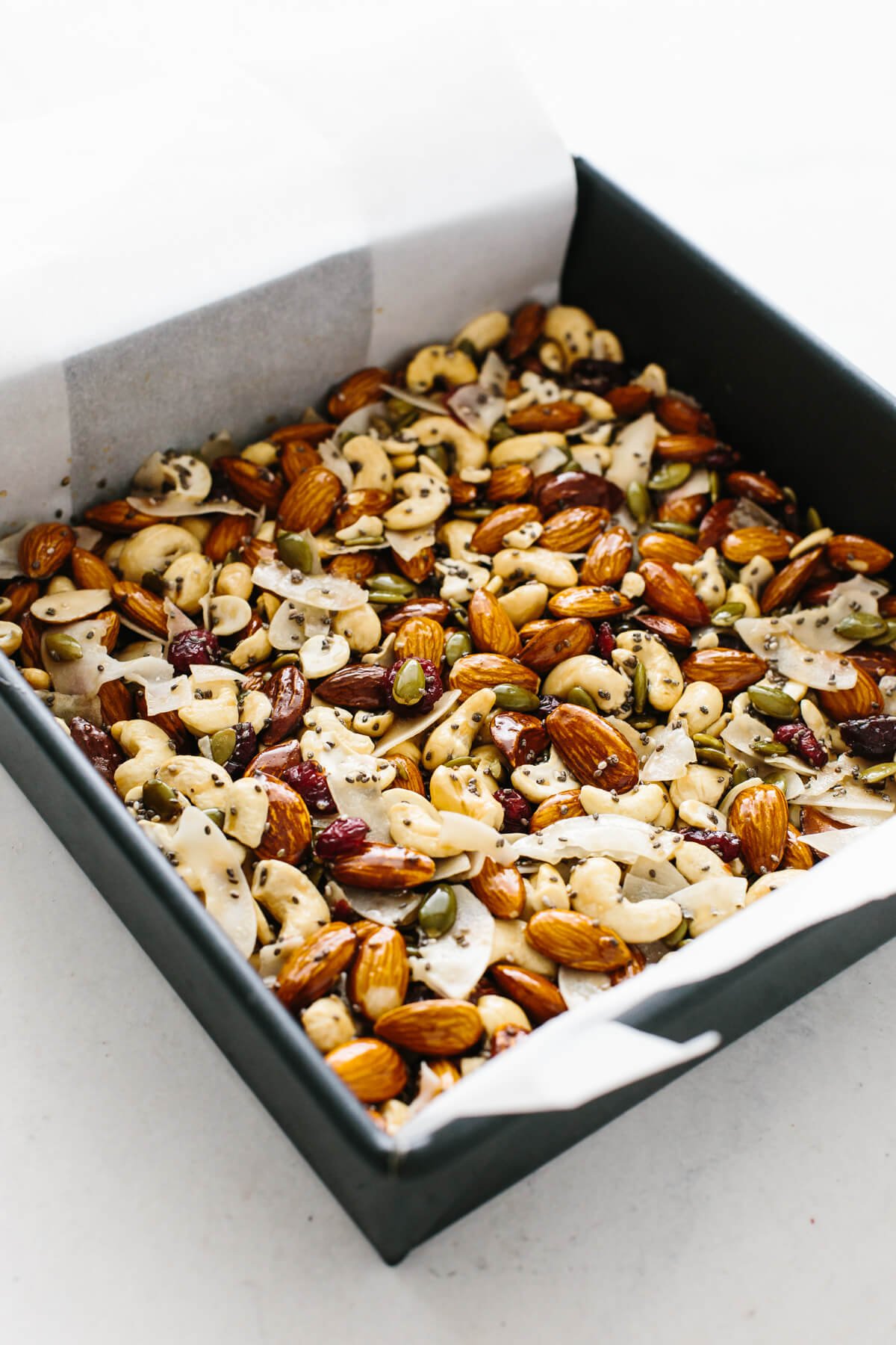 Healthy homemade trail mix granola bars that are gluten-free and paleo friendly! Homemade granola bar ingredients in a baking pan.