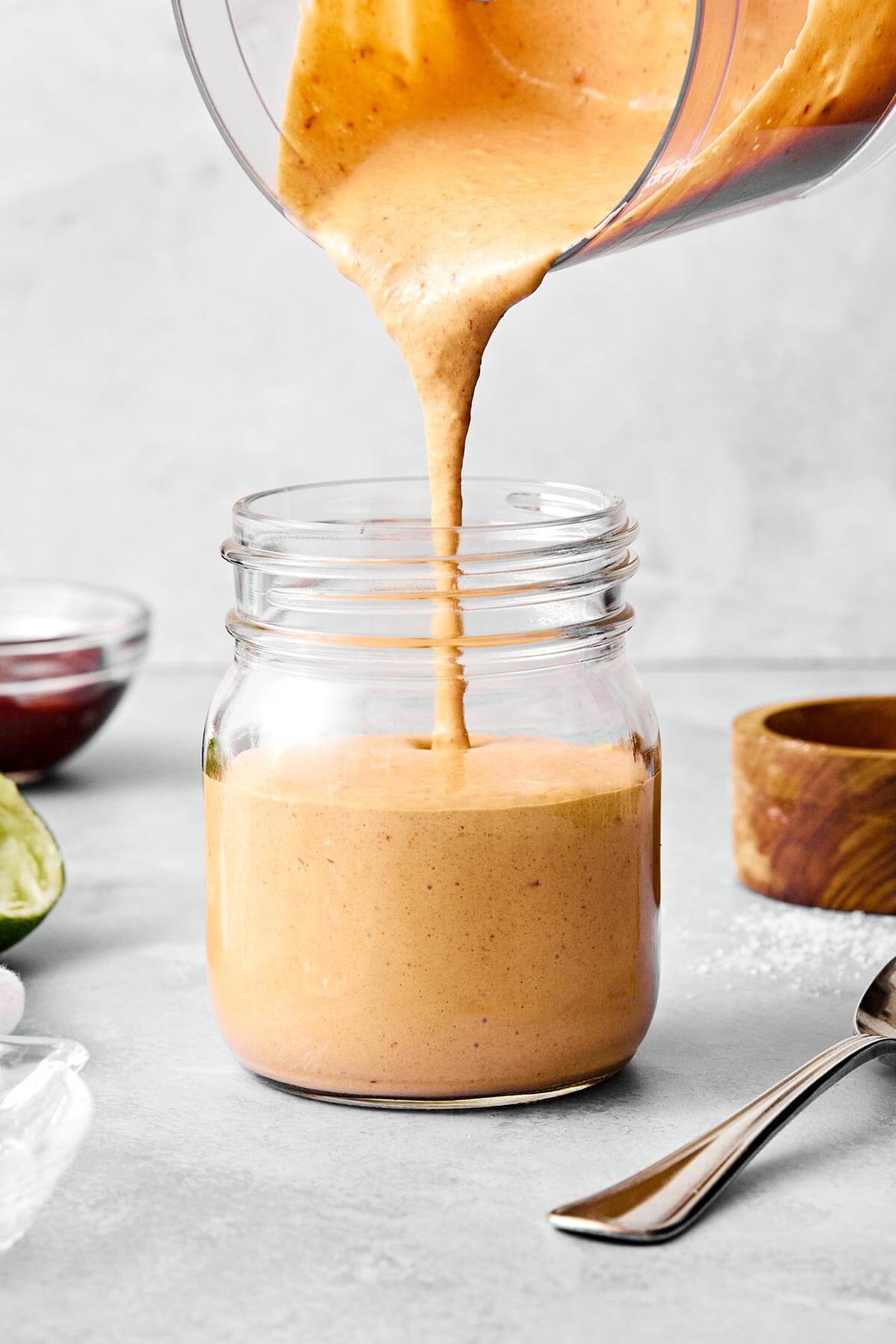 Pouring chipotle sauce into a jar.