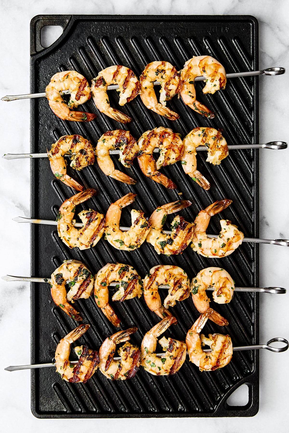 This grilled shrimp is a quintessential summertime grilling recipe! It's made with the best shrimp marinade and is perfect for your next BBQ. Grilling shrimp skewers on a grill pan.