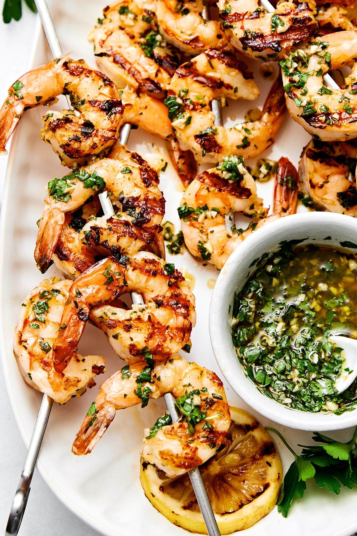 This grilled shrimp is a quintessential summertime grilling recipe! It's made with the best shrimp marinade and is perfect for your next BBQ. Grilled shrimp skewers with herb sauce.