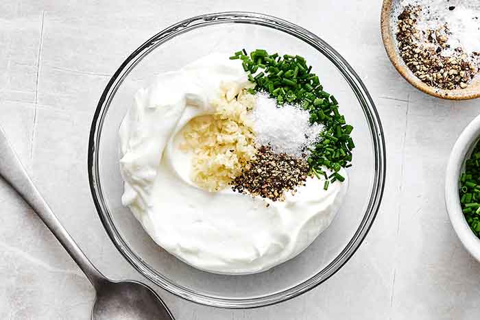 Mixing garlic yogurt sauce for zucchini fritters.