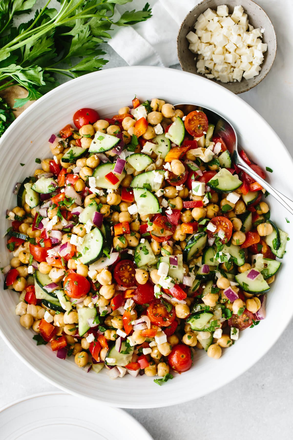This mediterranean chickpea salad is the ultimate summer salad that's easy and healthy! Mediterranean chickpea salad in a large white bowl on a table.