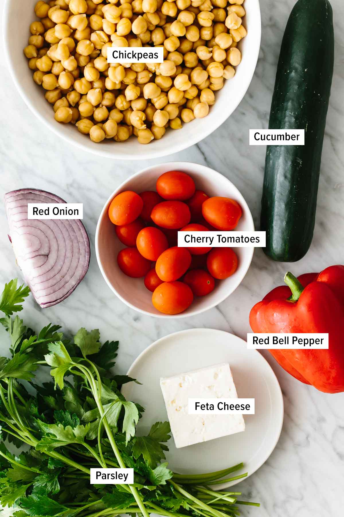 This mediterranean chickpea salad is the ultimate summer salad that's easy and healthy! Ingredients for making the chickpea salad on a table top.