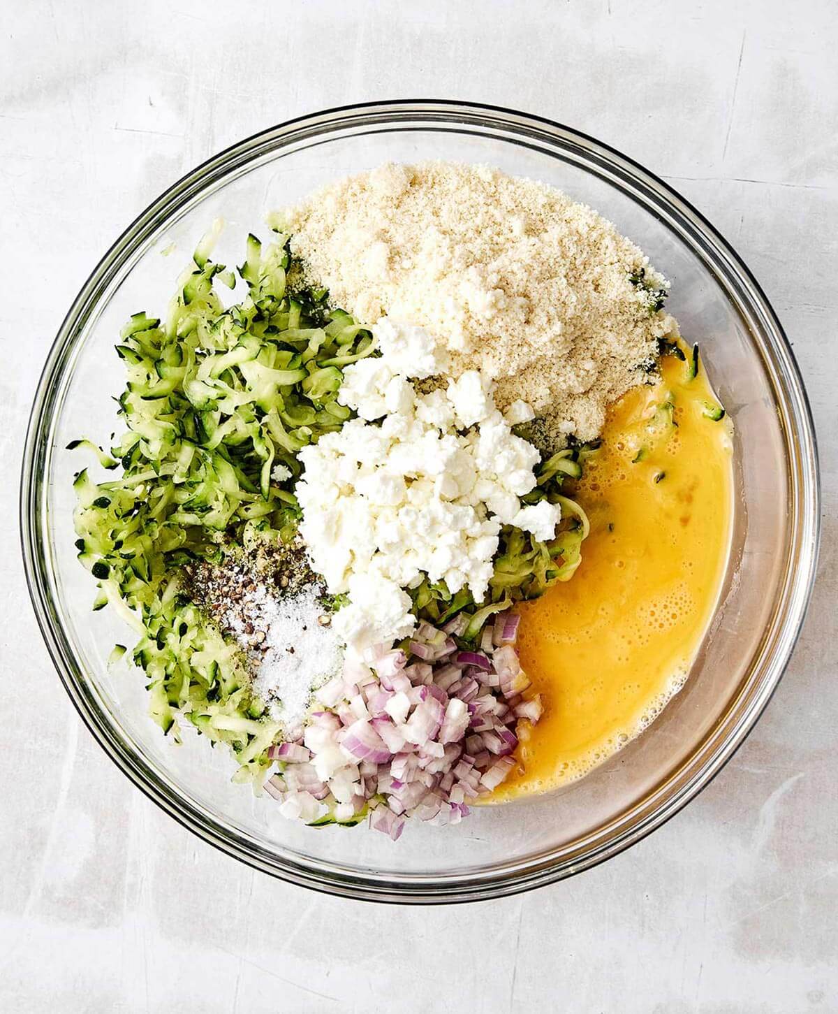 Mixing zucchini fritters ingredients.