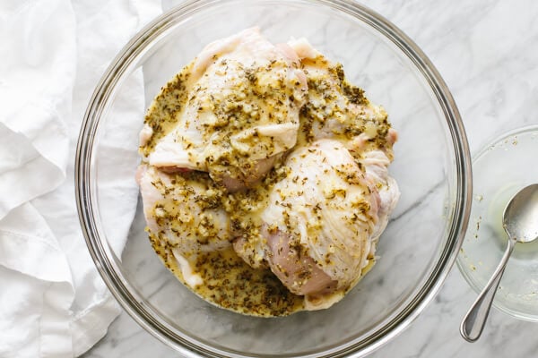 Pouring the marinade on top of chicken thighs.