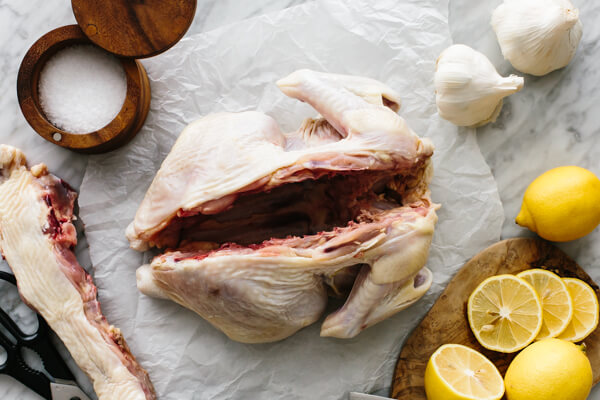 Backbone removed from a spatchcock chicken on a table.