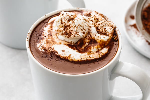 A whit mug with hot chocolate and whipped cream.
