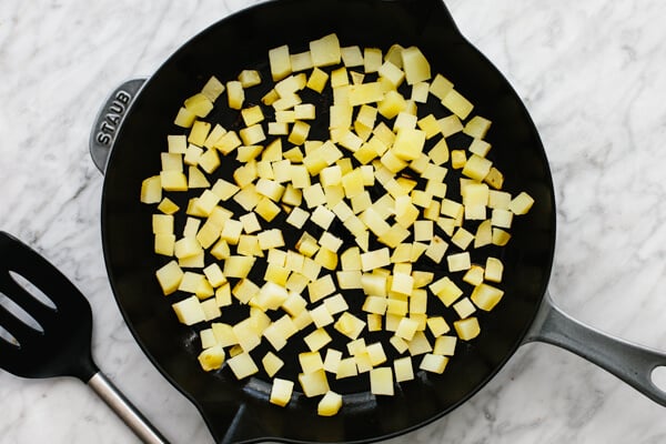 Sauteeing the potatoes in pan.