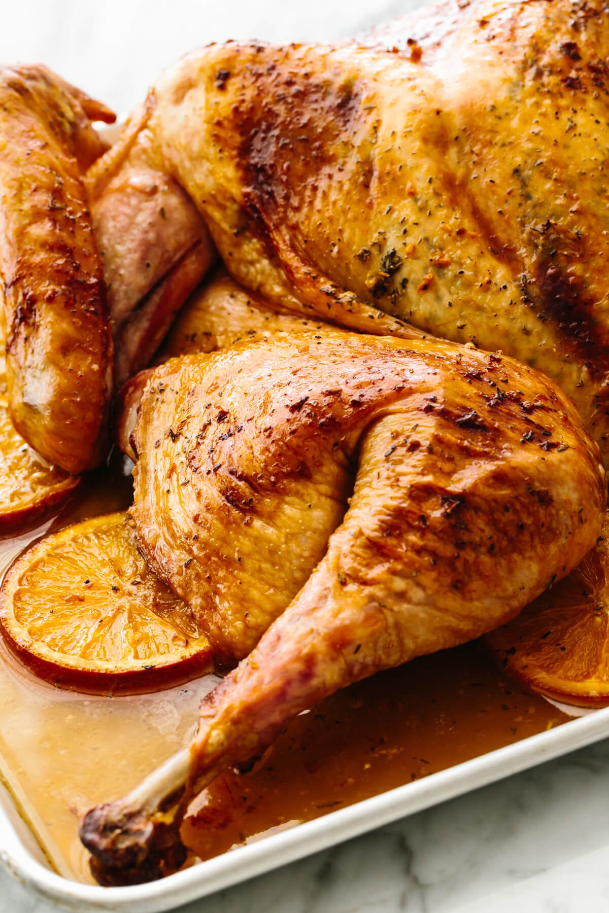 Maple orange glazed spatchcock turkey on a sheet pan.