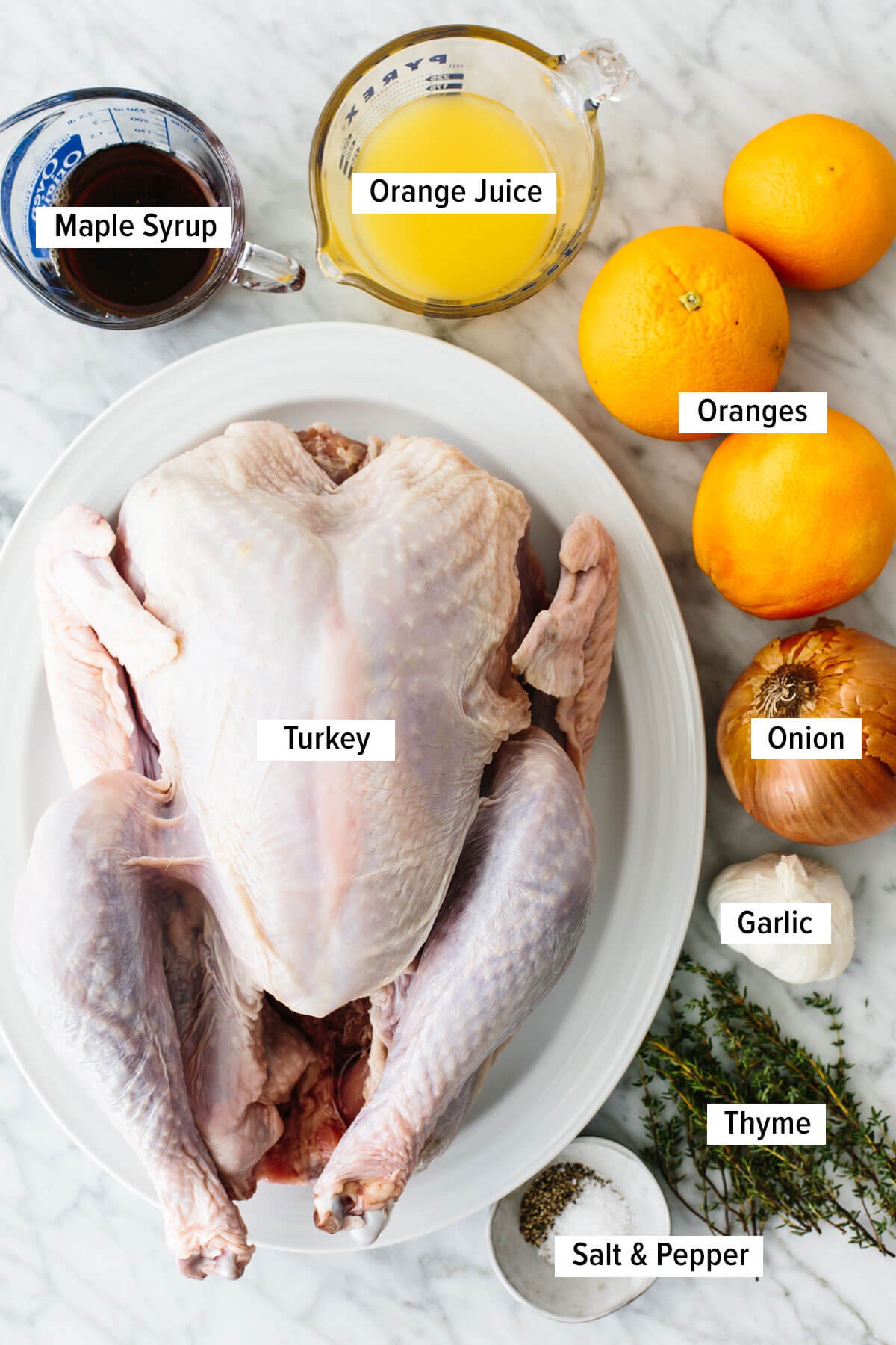 This maple orange spatchcock turkey is here to steal the Thanksgiving spotlight! It's juicy, sweet, citrusy, and perfectly crispy. Ingredients for a maple orange glazed spatchcock turkey on a table.
