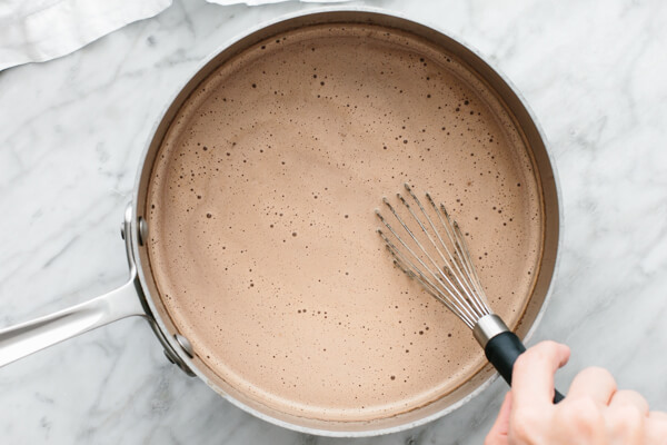 Whisking Nutella hot chocolate in a pot.