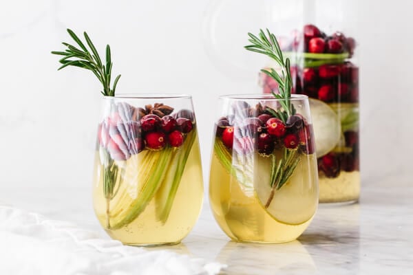 Glasses of white Christmas sangria with rosemary.