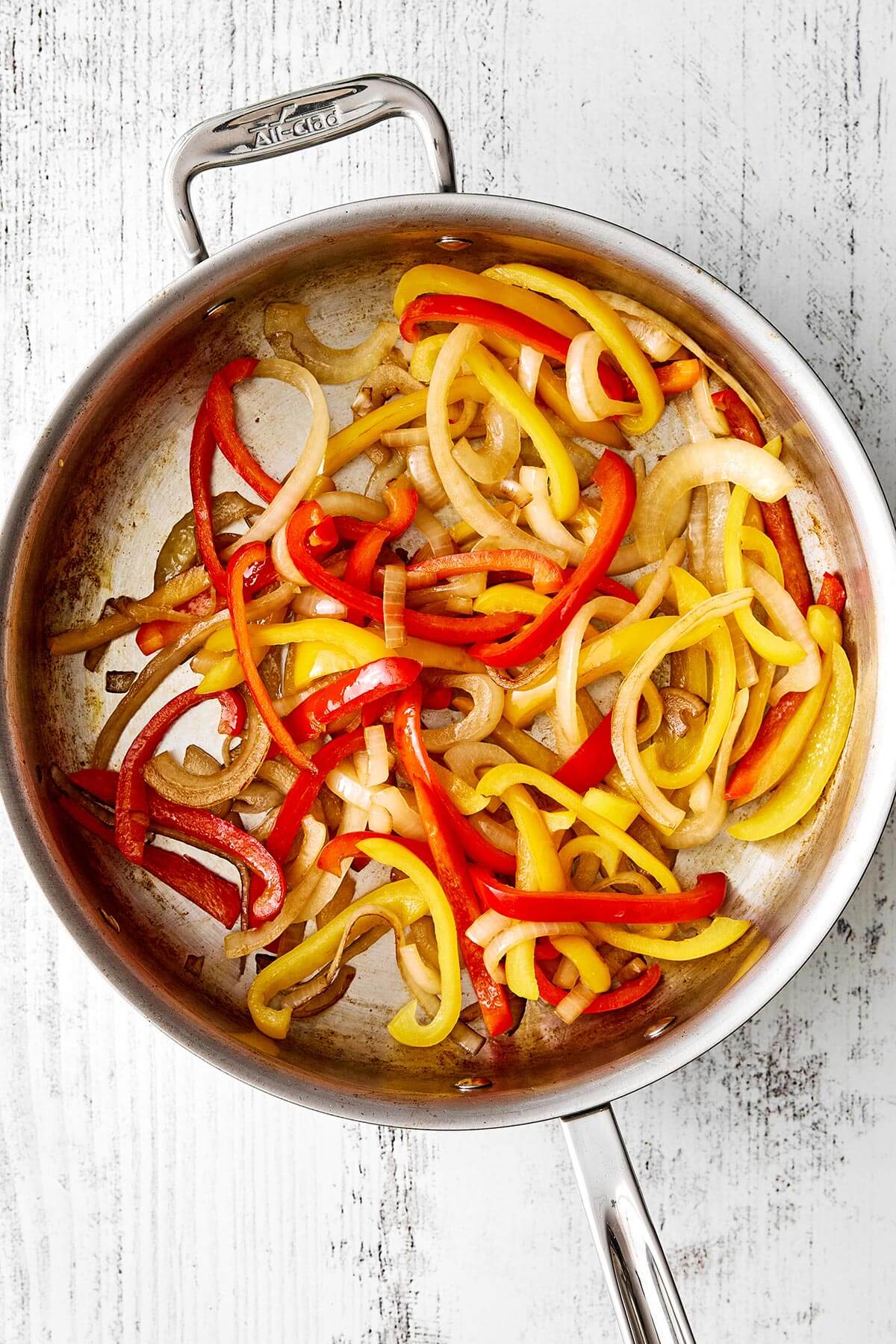 Sauteed bell peppers and onions in a skillet.