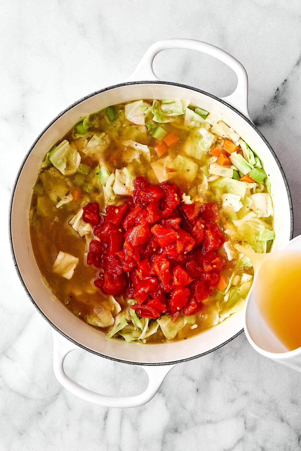 This cabbage soup is just what you need for soup season. It's light and simple, but extremely healthy, comforting, and delicious! Making cabbage soup in a pot.