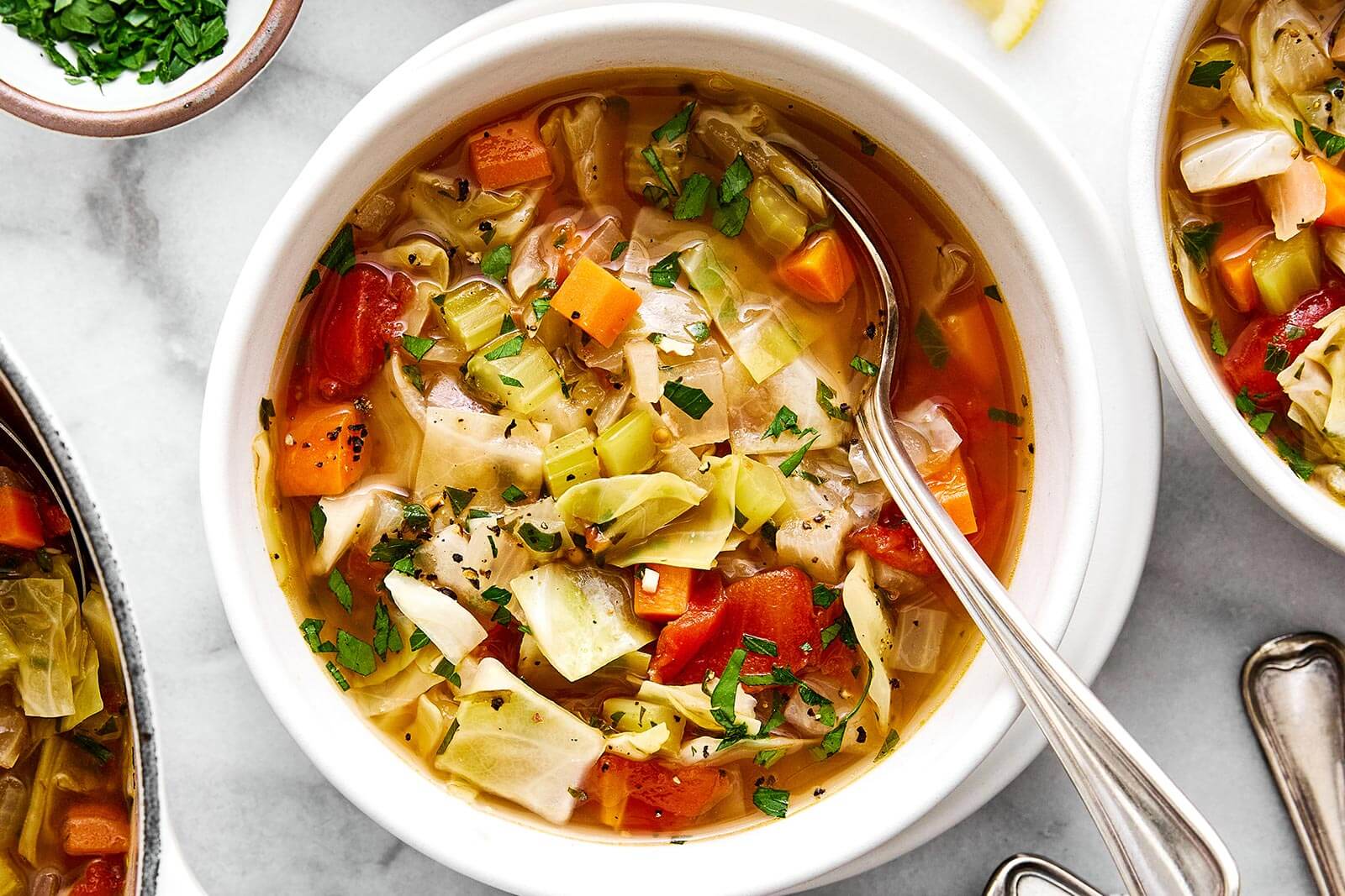 A white bowl of cabbage soup.