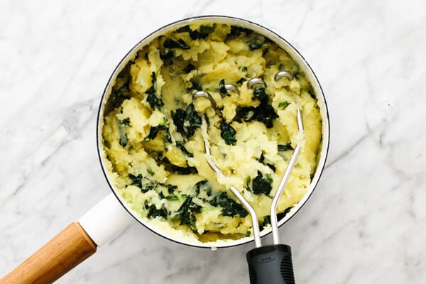 Mashing colcannon in a pot.