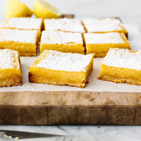 Sliced lemon bars on a wooden board.