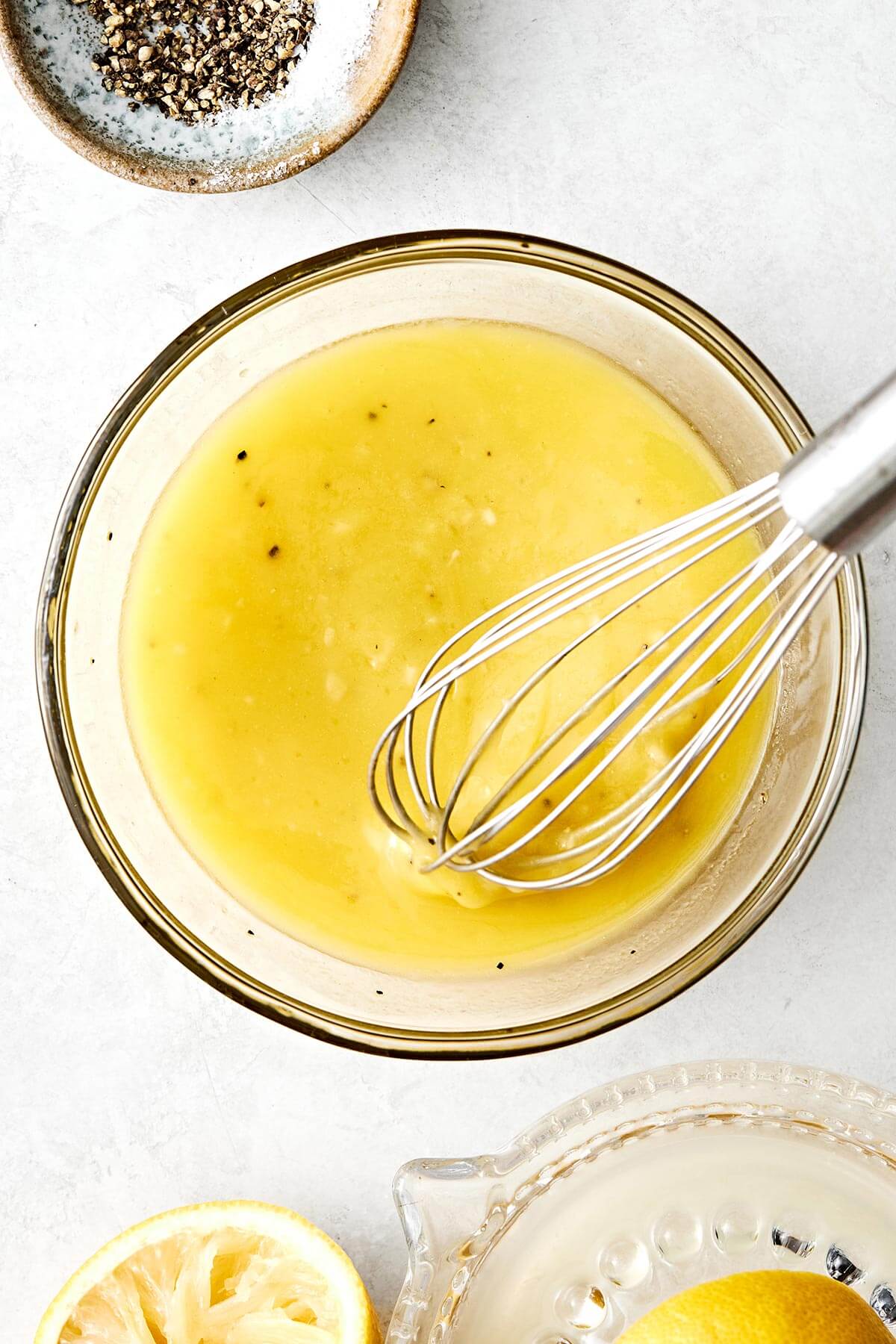 This lemon vinaigrette is a staple dressing that instantly brightens any salad or veggies, and tastes much better than store-bought versions! Whisking lemon vinaigrette in a bowl.