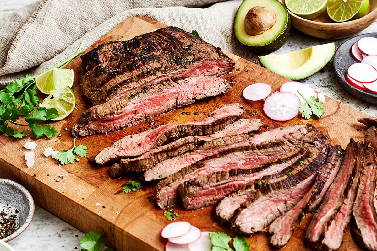 When it comes to the best carne asada, nothing beats this tried and true recipe loaded with authentic Mexican flavor! Slicing carne asada on a wooden board