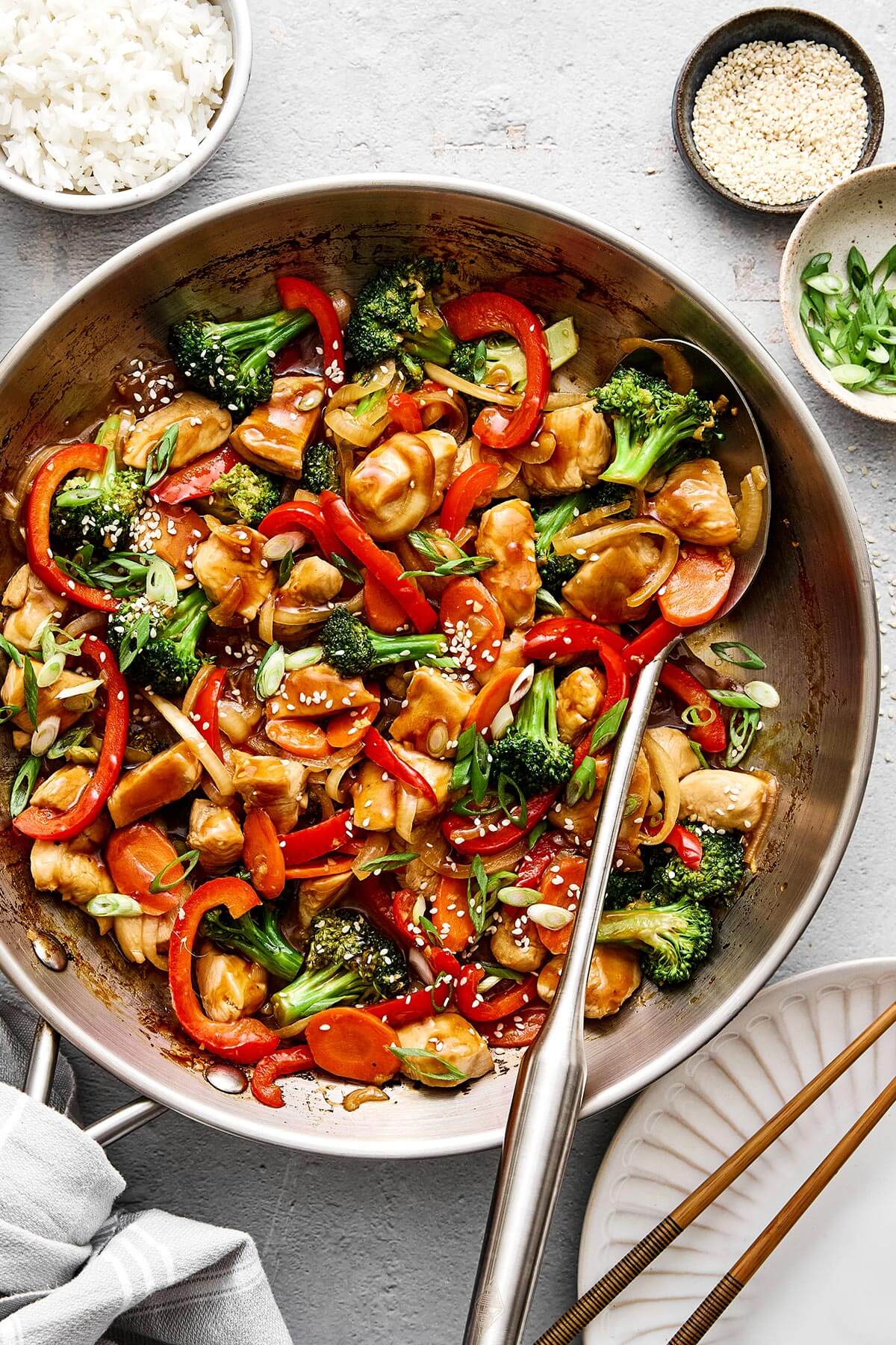 An easy, healthy chicken stir-fry dinner packed with flavor! It's got juicy chicken, loads of veggies, and the best savory-sweet sauce. A pan with chicken stir-fry.