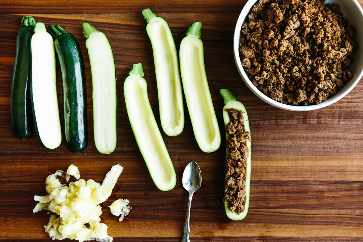 Scooping out zucchini to make stuffed zucchini boats