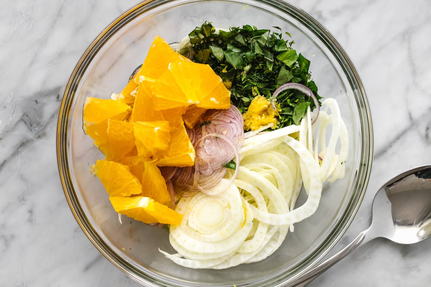 Mixing fennel orange mixture in a bowl for slow roasted salmon