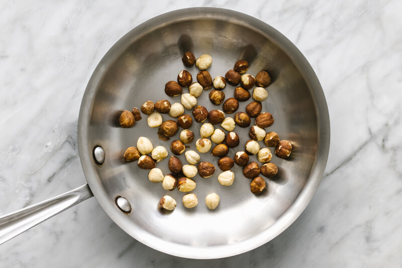 A pan toasting hazelnuts for romesco sauce