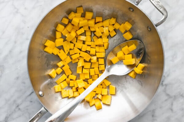 A wok with stir fry butternut squash