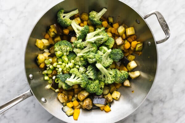 A wok filled with butternut squash and eggplant stir fry