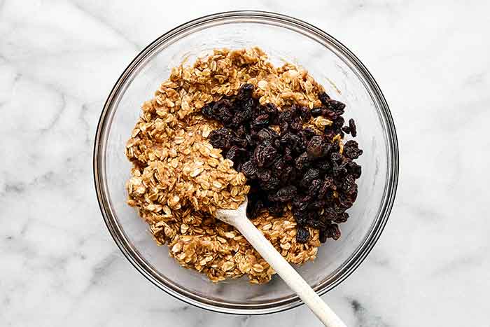Folding raisins in cookie dough.