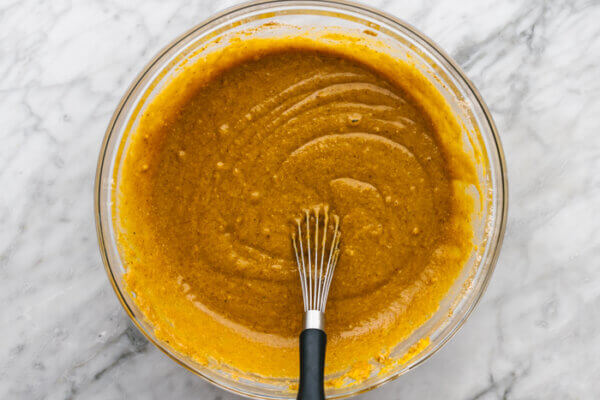 Stirring gluten-free pumpkin pie batter in a bowl.