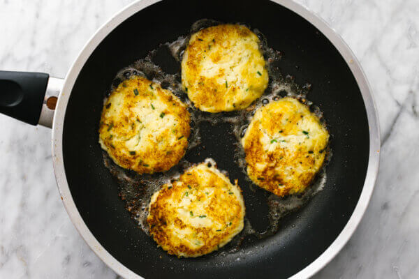 A pan cooking potato pancakes.