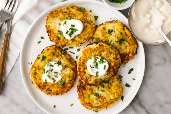 A white plate filled with potato pancakes.