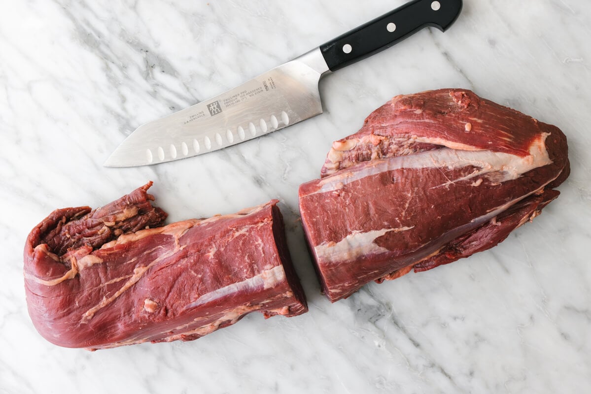 Slicing a beef tenderloin in half.