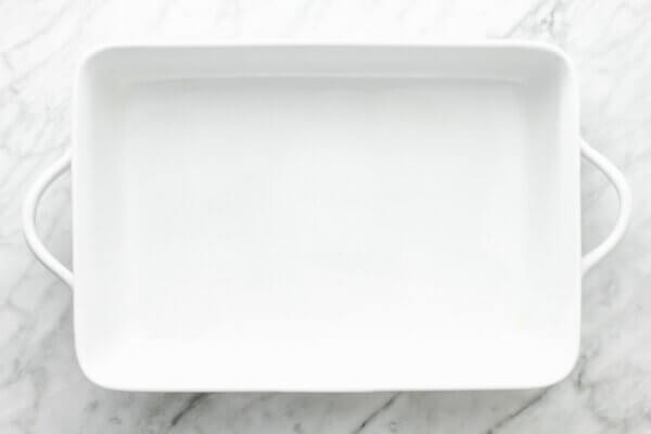 A greased pan for turmeric chicken and rice casserole