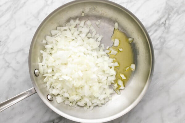 A pan of sauteed onions for turmeric chicken and rice casserole