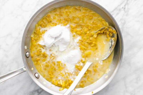 Stirring coconut mixture in pan for turmeric chicken and rice casserole