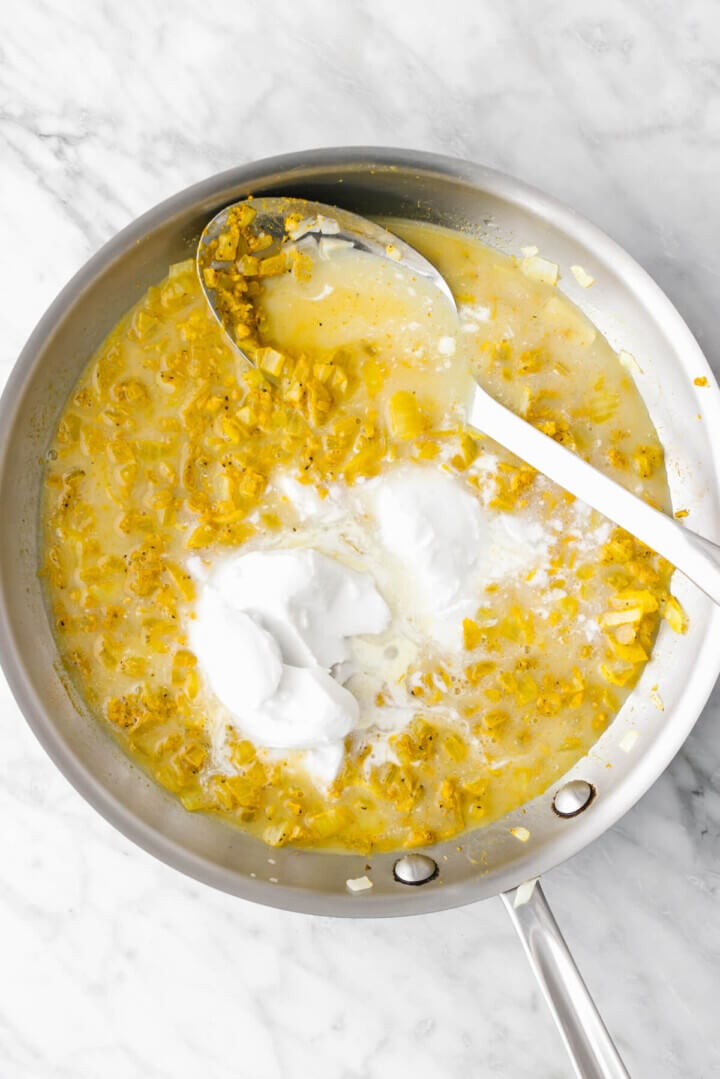 Cooking onion mix in a pan for turmeric chicken and rice casserole