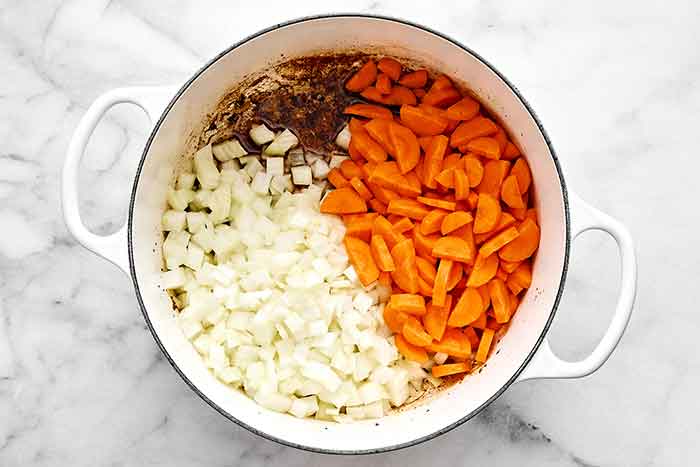 Adding veggies in a pot.