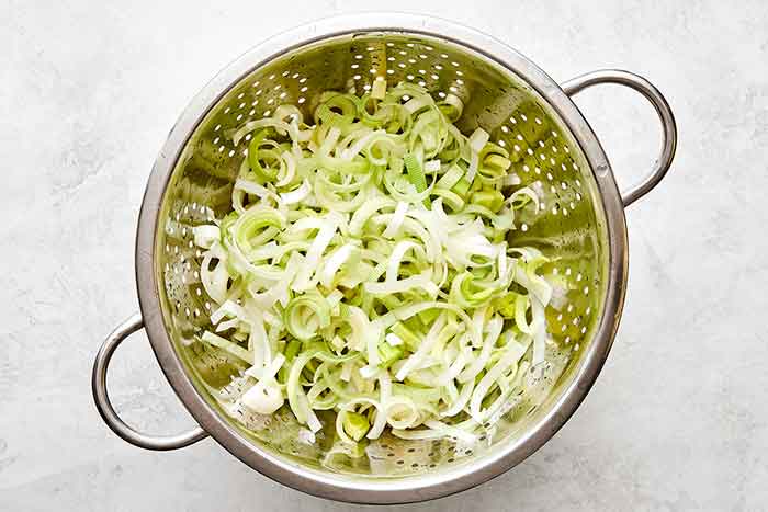 Washing leeks in colander.