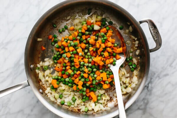 A pan with cooked veggies for shrimp fried rice