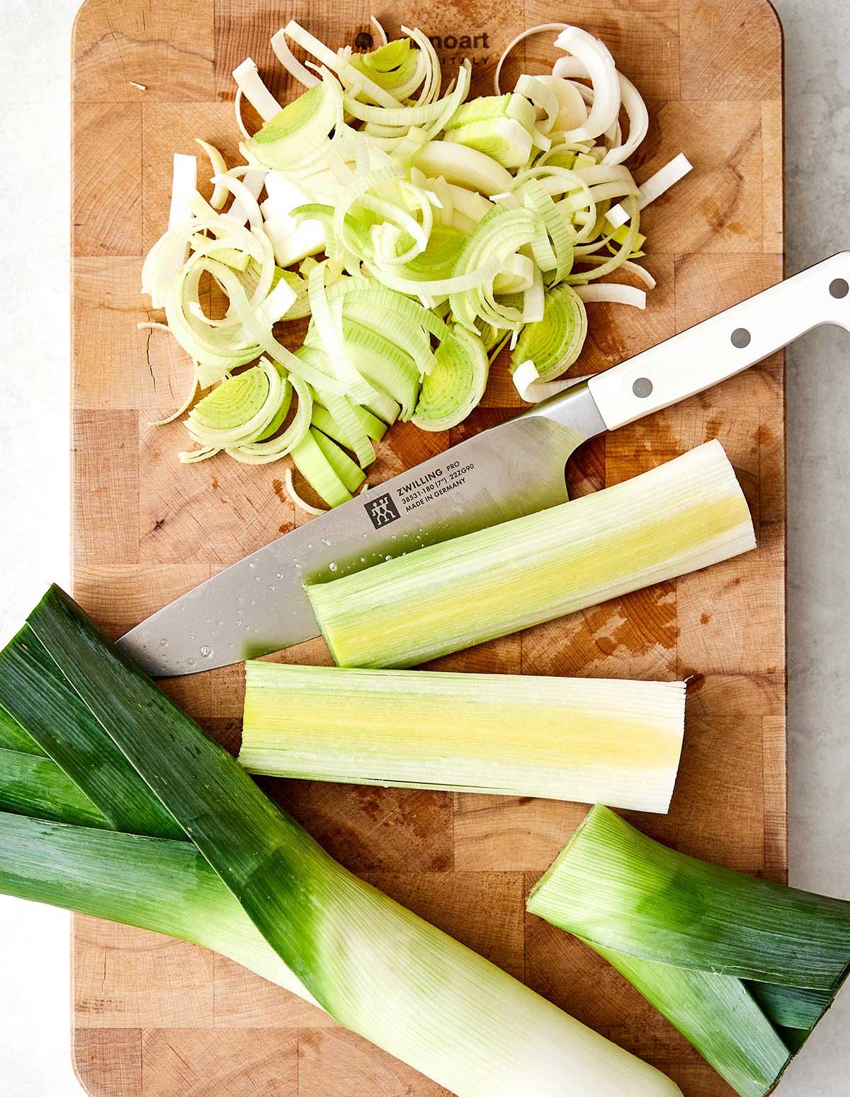 Slicing leeks on a board.