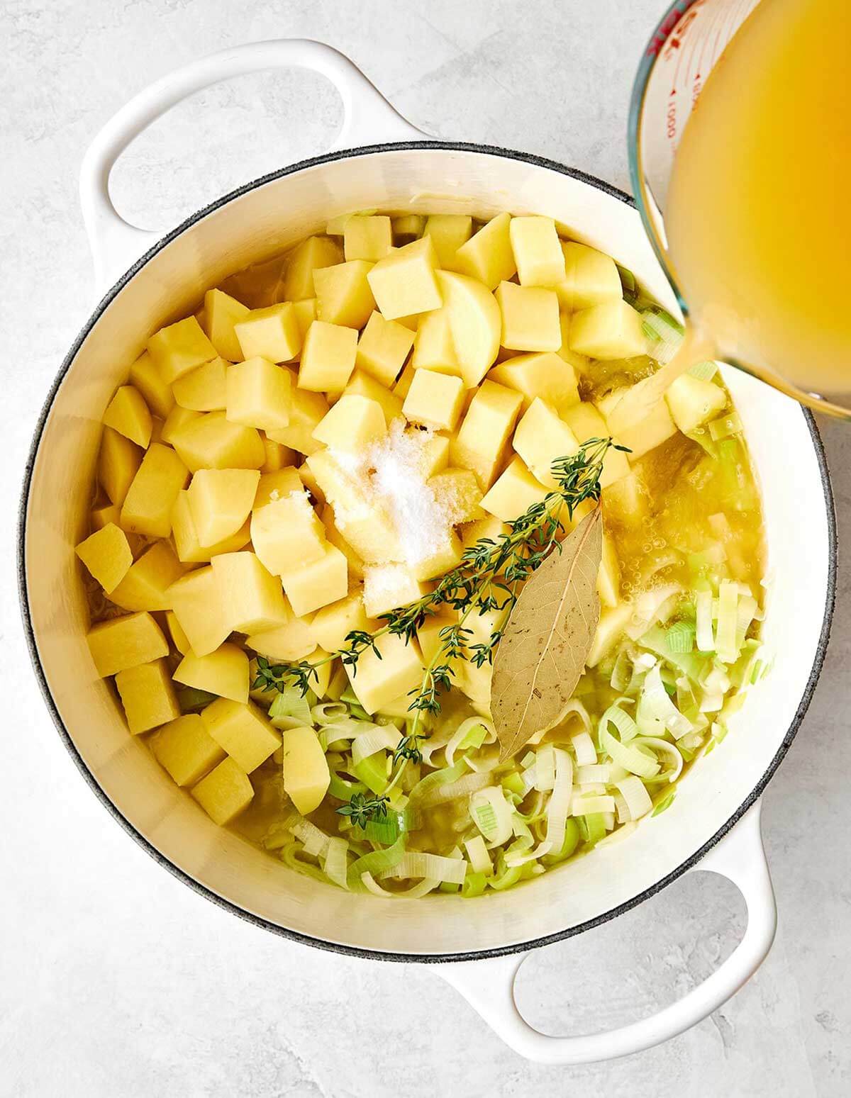 Adding broth to potato leek soup.